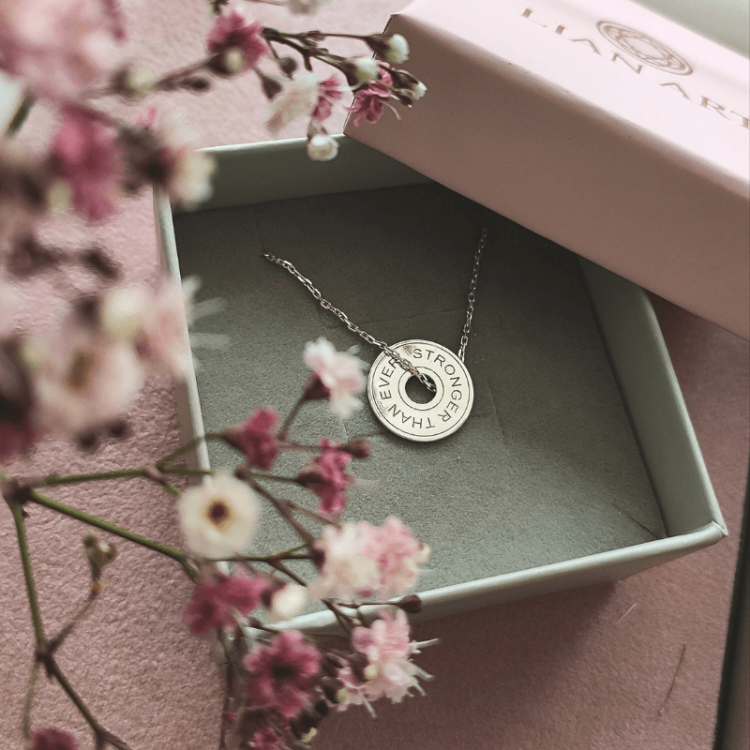 naszyjnik z ciężarkiem i napisem Stronger Than Ever